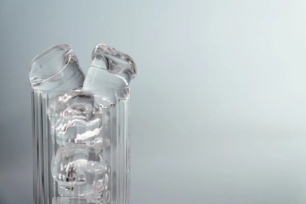 Стеклянные бутылки с водой на светлом фоне
